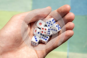 Man holding a few small game dice showing different numbers in hand, group of objects closeup. Math randomness, entropy,