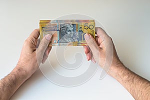 Man holding fifty Australian Dollar in his hands