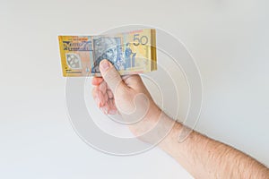 Man holding fifty Australian Dollar in his hands