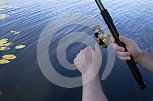 Man holding fish bait and fishing rod in his hands.Hobby and leisure concept.