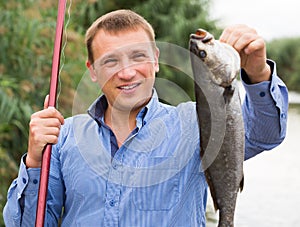 Man holding fish after fishing