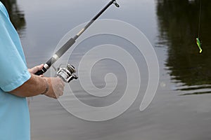 Man Holding Fishing Pole by the Water