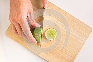 A man is holding fresh organic lemon with his hand on the wooden tray. lemon cuted for lemonade juice. lemon is citrus vegetable