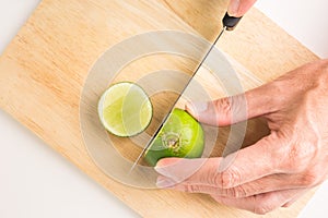 A man is holding fresh organic lemon with his hand on the wooden tray. lemon cuted for lemonade juice. lemon is citrus vegetable