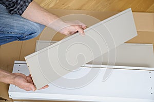 A man is holding a furniture board