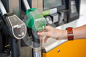 Man holding a gasoline nozzle in his hand on self-service filling station in Europe