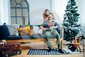 Man holding a gift box while her girlfriend covering his eyes with hands