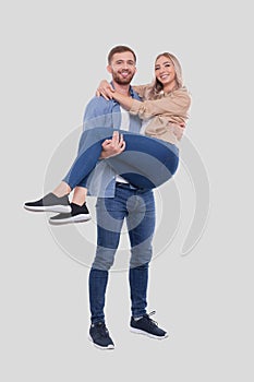 Man Holding Girl in his Arms. Couple Standing Isolated