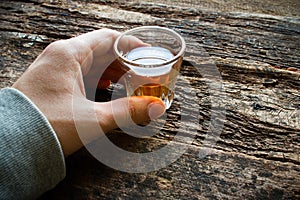 Man holding a glass of alcohol on table