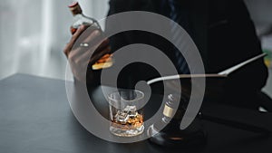 Man holding a glass of brandy, he is drinking brandy in a bar, drinking alcohol impairs driving ability and can damage health. The