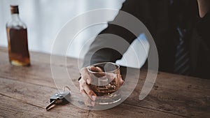 Man holding a glass of brandy, he is drinking brandy in a bar, drinking alcohol impairs driving ability and can damage health. The
