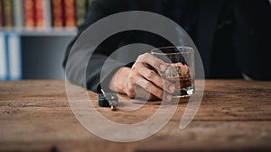 Man holding a glass of brandy, he is drinking brandy in a bar, drinking alcohol impairs driving ability and can damage health. The