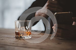 Man holding a glass of brandy, he is drinking brandy in a bar, drinking alcohol impairs driving ability and can damage health. The