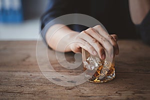 Man holding a glass of brandy, he is drinking brandy in a bar, drinking alcohol impairs driving ability and can damage health. The