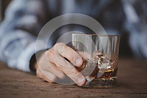 Man holding a glass of brandy, he is drinking brandy in a bar, drinking alcohol impairs driving ability and can damage health. The