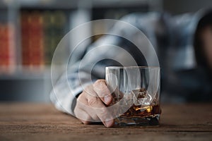 Man holding a glass of brandy, he is drinking brandy in a bar, drinking alcohol impairs driving ability and can damage health. The