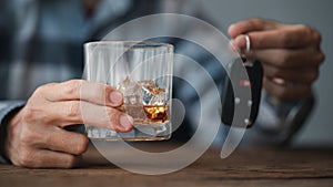 Man holding a glass of brandy, he is drinking brandy in a bar, drinking alcohol impairs driving ability and can damage health. The