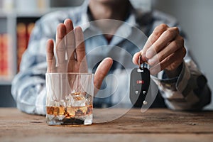 Man holding a glass of brandy, he is drinking brandy in a bar, drinking alcohol impairs driving ability and can damage health. The