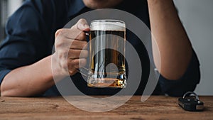 Man holding a glass of brandy, he is drinking brandy in a bar, drinking alcohol impairs driving ability and can damage health. The