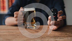 Man holding a glass of brandy, he is drinking brandy in a bar, drinking alcohol impairs driving ability and can damage health. The