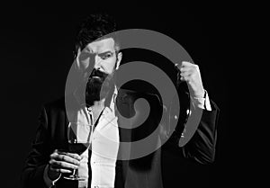 Man holding glass of cabernet or red wine and bottle