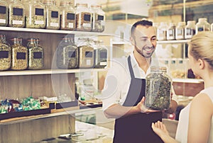 Man holding glass can with dried herbs