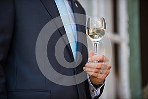Man holding a glass of white wine