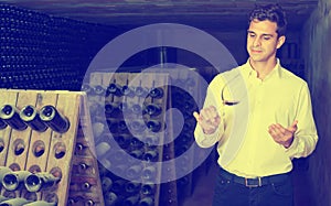 Man holding glass with wine in cellar