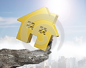 Man holding golden house on cliff edge