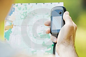 Man holding a GPS receiver and plan in his hand.