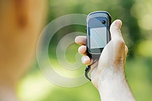 Man holding a GPS receiver and plan in his hand.