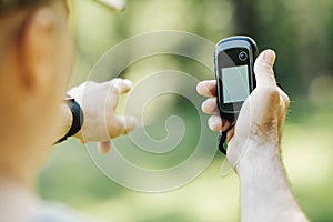 Man holding a GPS receiver and plan in his hand.