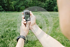 Man holding a GPS receiver and plan in his hand.