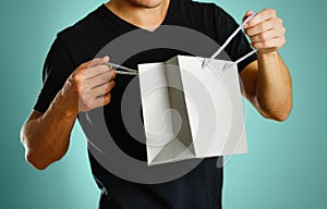 A man holding a gray gift bag. Close up. Isolated background