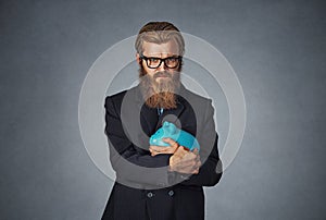 Man holding with greedy hand gesture the piggy bank