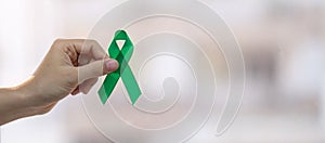 Muž držení zelený stuha podporující lidé žijící a nemoc. játra žluč potrubí ledvina rakovina a 