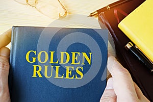 Man holding guide with title golden rules.