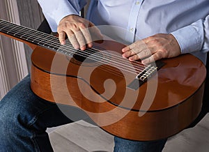 Man is holding a guitar. Preparing to play a musical instrument