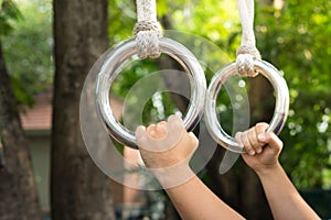 Man holding gymnastic rings at outdoor location