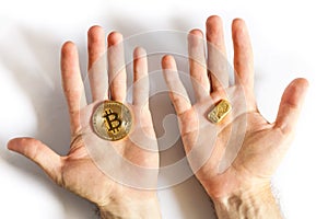 Man holding in hand a gold bar and golden coin Bitcoin