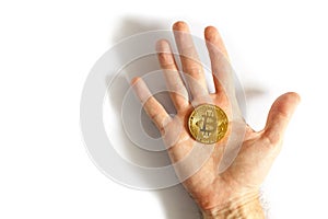 Man holding in hand gold Bitcoin on white background