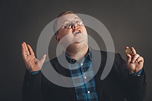 Man holding in hand symbol of bitcoin crypto currency and say thanks God