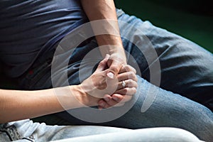 Man holding hand of woman with wedding ring on finger