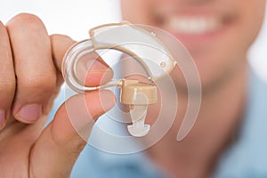 Man Holding Hearing Aid