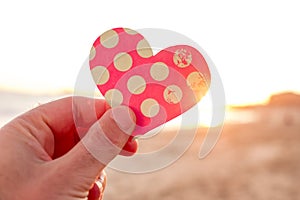 Man holding a heart cut at dawn or sunset