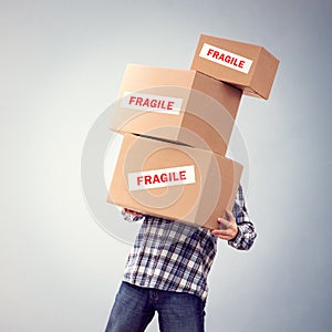 Man holding heavy fragile cardboard boxes relocation, moving house or courier delivery