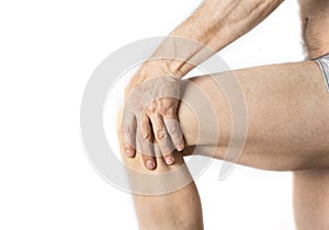 Man is holding his aching knee with a hand