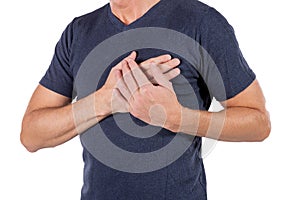 Man holding his chest with hands, having heart attack or painful cramps, pressing on chest with painful expression on white