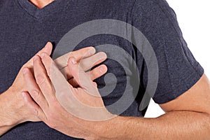 Man holding his chest with hands, having heart attack or painful cramps, pressing on chest with painful expression on white