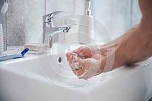 Man holding his cupped palms under running water